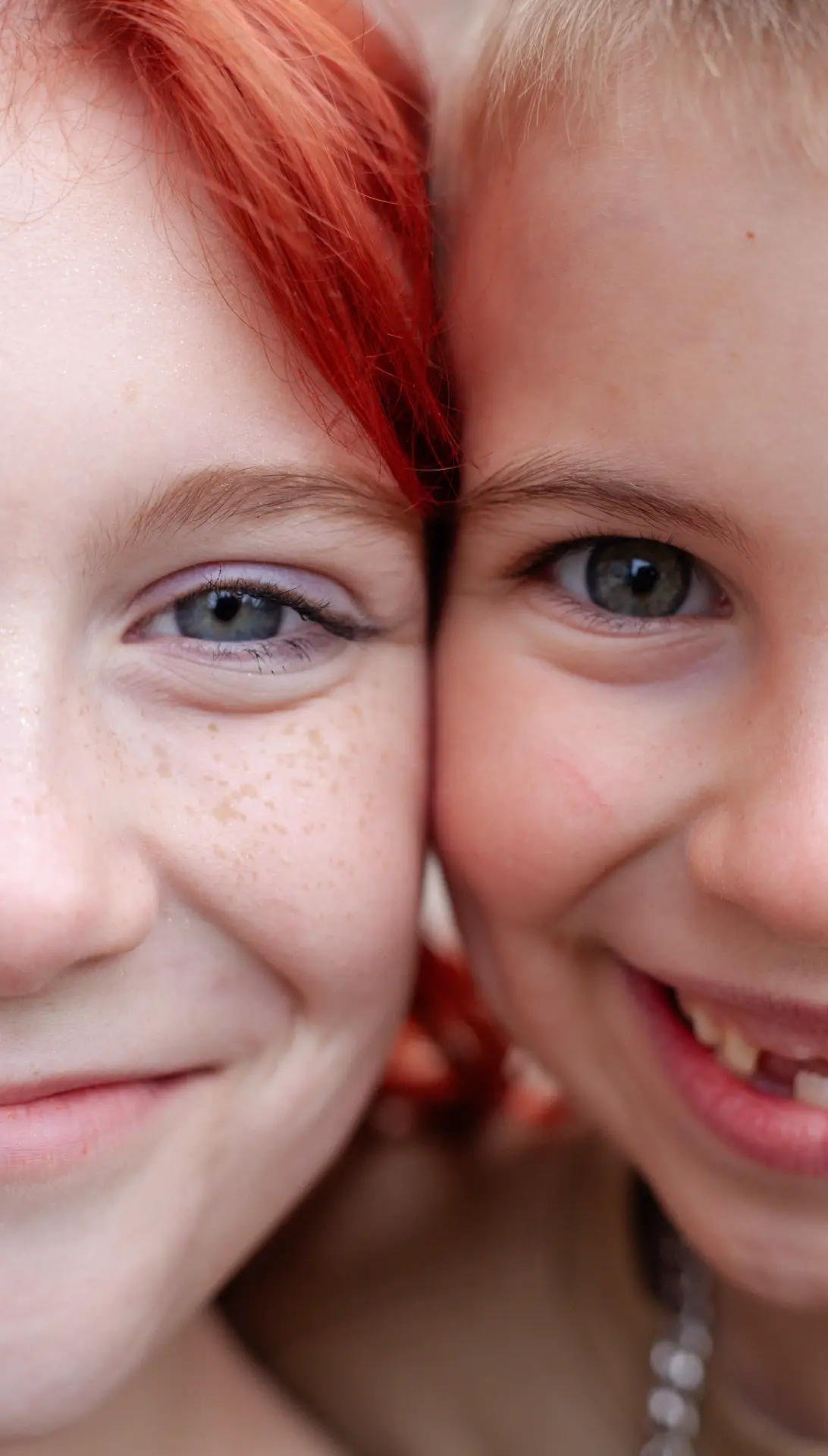 Close-up of two smiling children with red hair and freckles.