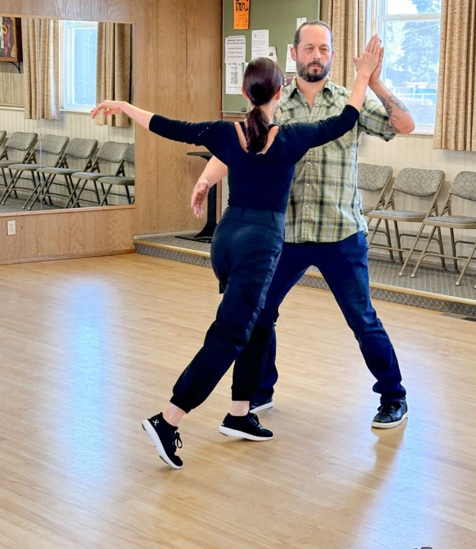 Couple dancing gracefully in a bright studio.