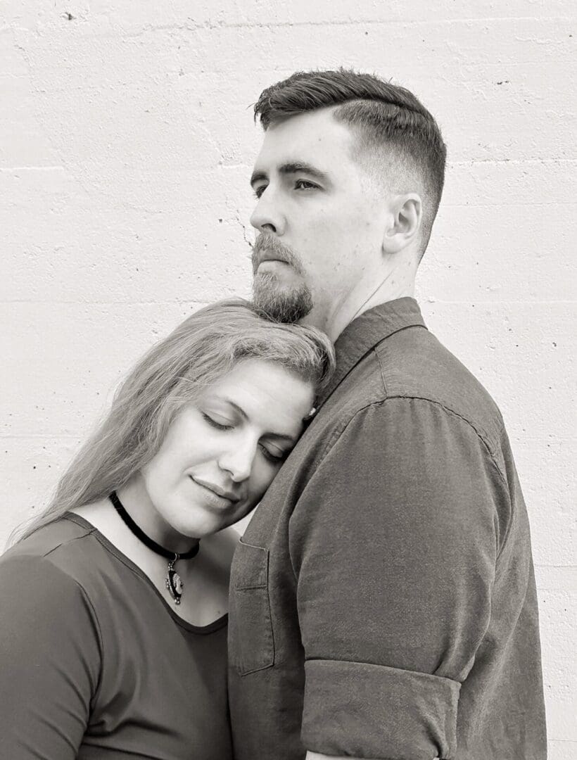 A woman resting her head on a man's chest, both showing calm emotions.
