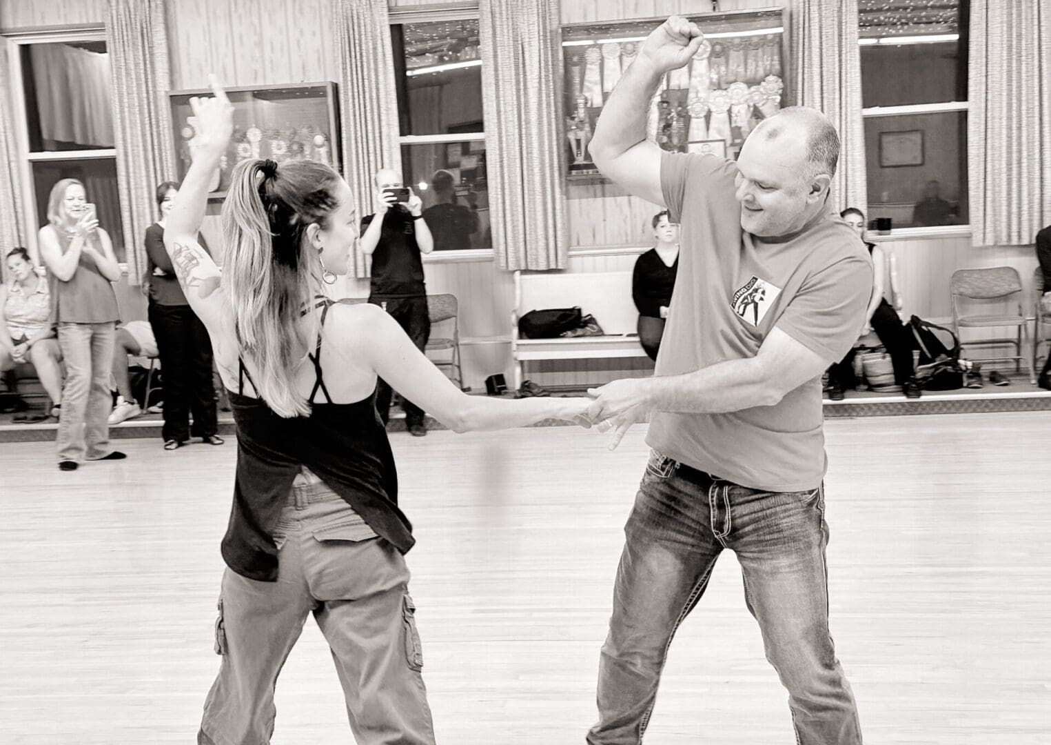 Couple dancing together in a lively indoor setting.