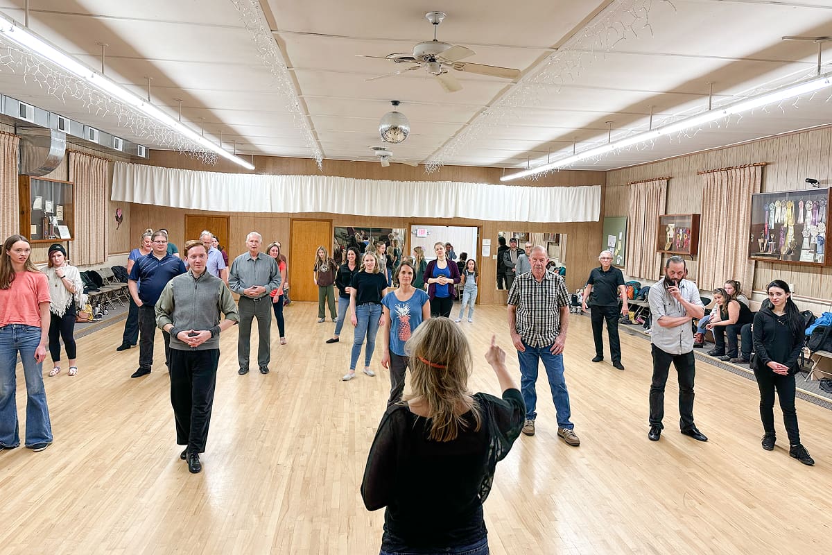 A group workshop with a speaker addressing attendees in a spacious room.