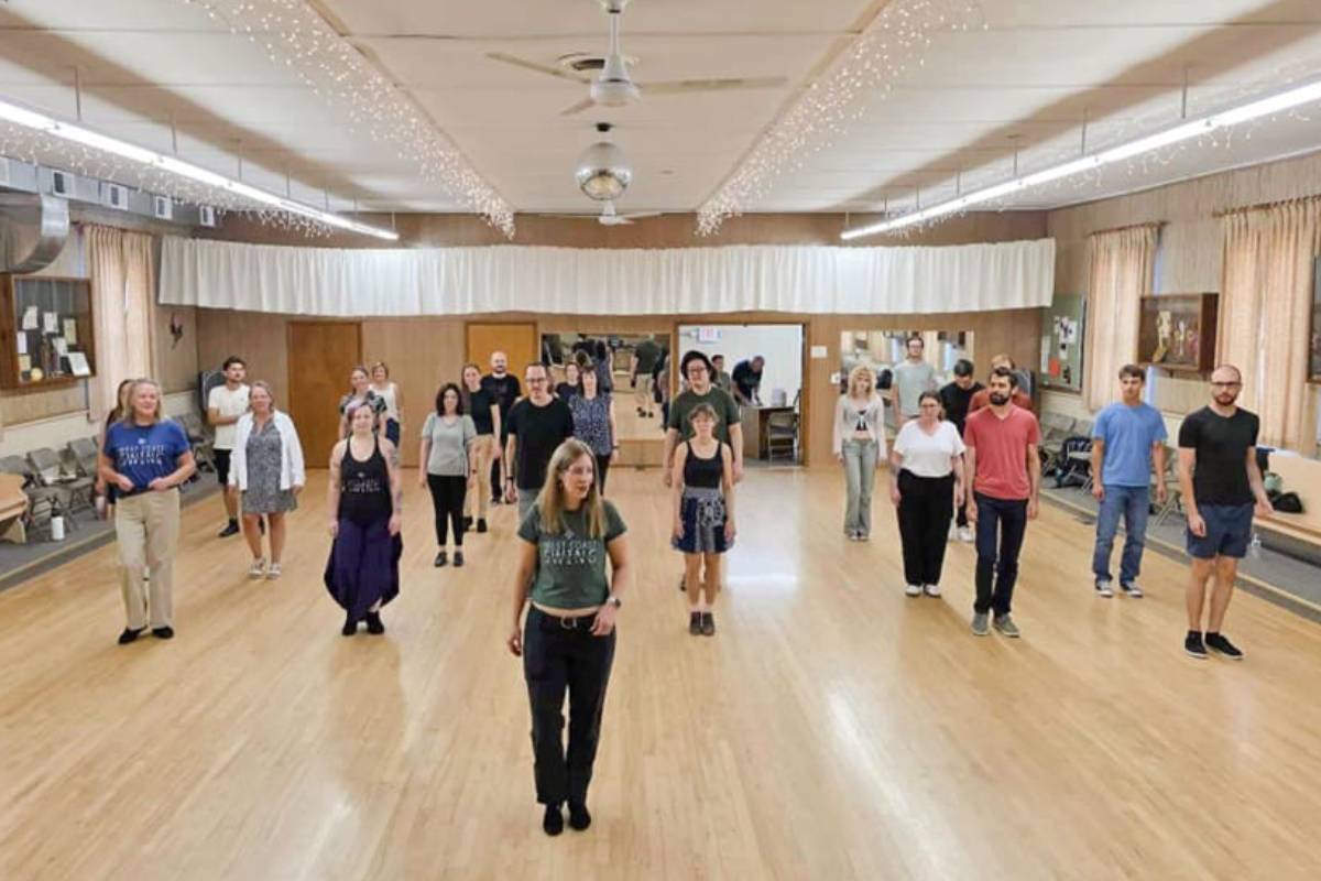 Group of people standing spaced out in a dance studio.