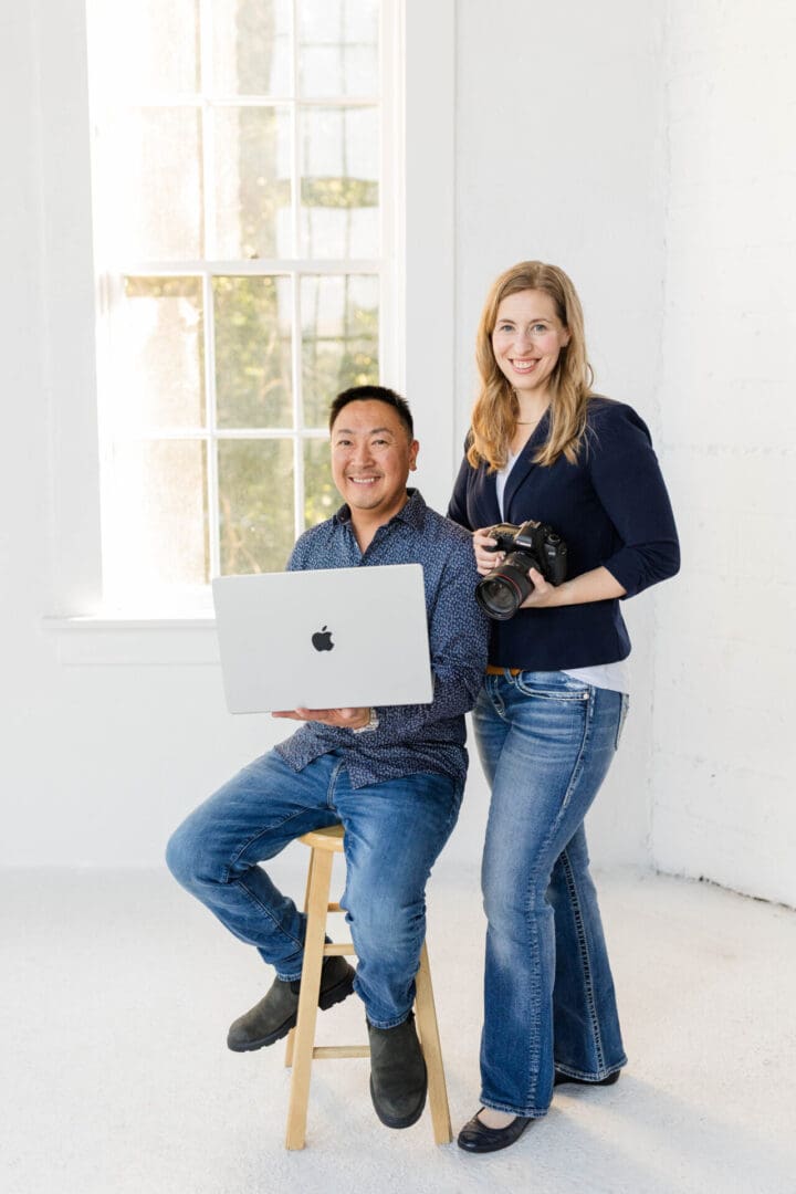Two people with laptop and camera.