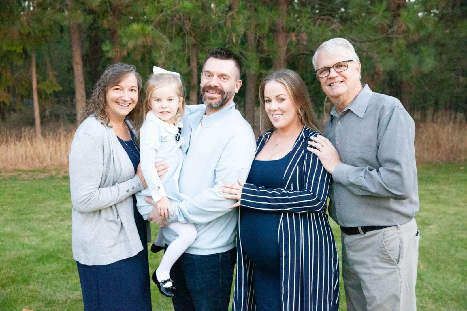 Family posing together in a park setting.